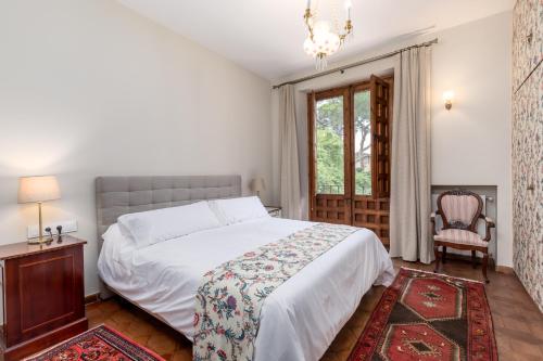 a bedroom with a bed and a chair and a window at Alquería Calatrava B&B in Burriana