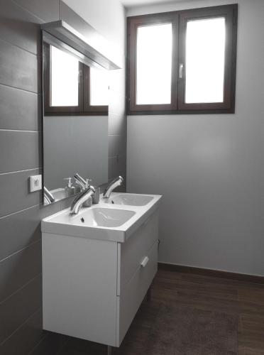 a white bathroom with a sink and two windows at Au chalet des quatre saisons in Ax-les-Thermes