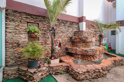 a brick building with a fountain in front of it at Turis Hotel Centro in Campo Grande