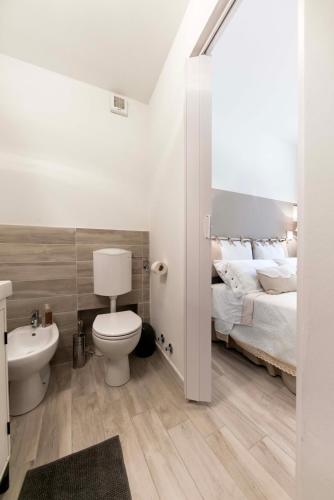 a bathroom with a bed and a toilet and a sink at Tosca's House in Palaia