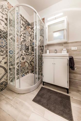 a bathroom with a shower and a sink and a mirror at Tosca's House in Palaia