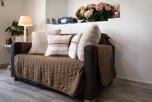 a couch with pillows on it in a living room at Tosca's House in Palaia