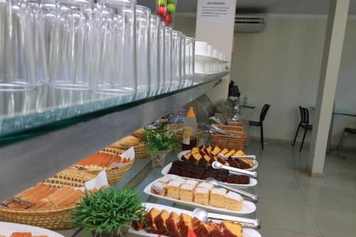a bakery with many different types of food on display at Turis Hotel Centro in Campo Grande