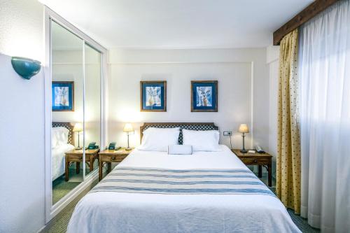 una habitación de hotel con una cama y un espejo en Ona Garden Lago, en Puerto de Alcudia