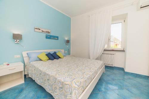 a blue bedroom with a bed and a window at Aquarius Maiori B&B in Maiori