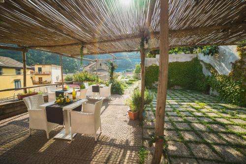 a patio with a table and chairs under a pergola at Aquarius Maiori B&B in Maiori