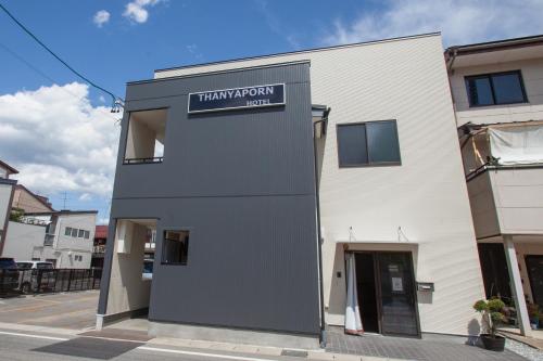 a building with a sign on the side of it at Thanyaporn Hotel in Takayama