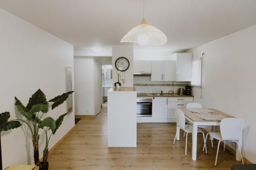 een keuken en eetkamer met een tafel en stoelen bij Appartement 4 personnes jardin et parking in Vannes