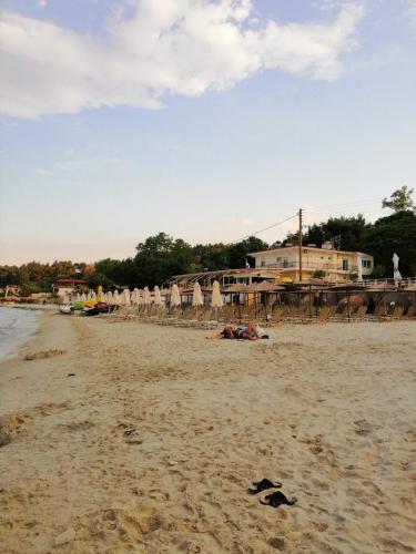 a beach with umbrellas and chairs on the sand at Next to the center!!! in Kallithea Halkidikis