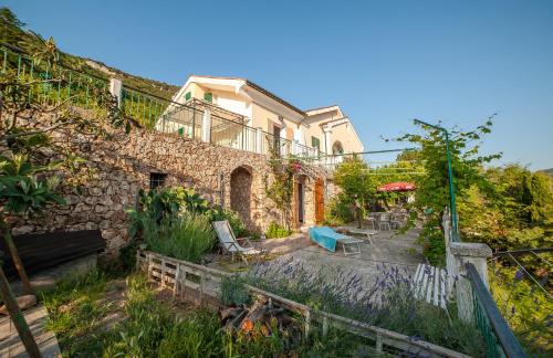 フィナーレ・リーグレにあるB&B Sopra il Borgoの庭の椅子とテーブル付き石造りの家