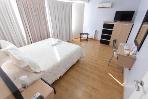 a hotel room with a bed and a television at Apart Hotel Rivadavia 815 in Neuquén