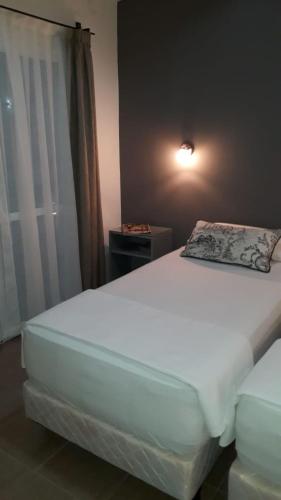 a bedroom with a large white bed with a window at Las Toscas Apart in Curuzú Cuatiá