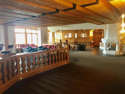a large room with wooden ceilings and chairs and a staircase at Lovely Studio Bristol with swimming-pool Villars in Villars-sur-Ollon
