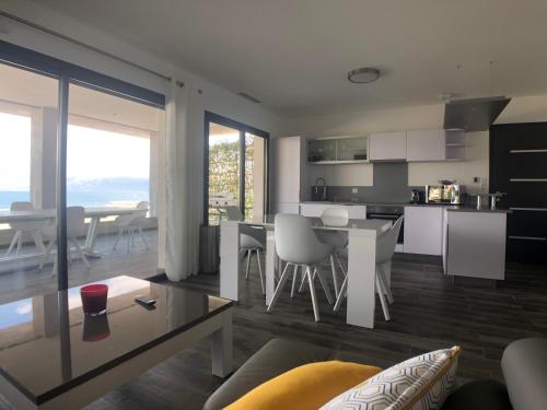 une cuisine et un salon avec une table et des chaises dans l'établissement Residence Capriona, à Porto Pollo