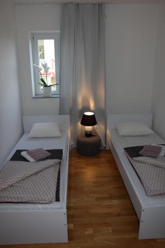 a room with two beds and a lamp in it at APP LU 5 in Novi Vinodolski