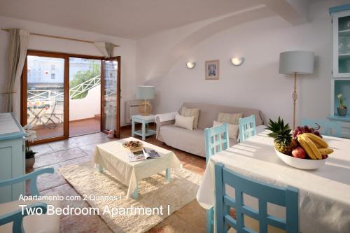 a living room with a table and chairs and a couch at Akisol Olhos de Água Ocean in Albufeira