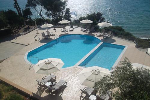 キリニにあるKastro Beach Hotelのパラソル付きのスイミングプールのオーバーヘッドビュー