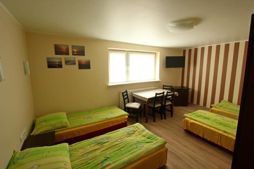 a room with four beds and a table with a window at U ELŻBIETY in Łeba