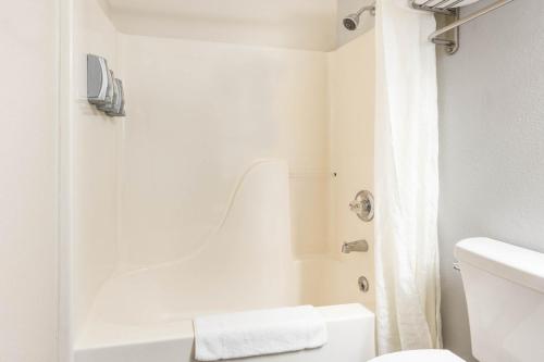 a white bathroom with a shower and a toilet at Super 8 by Wyndham Gardiner/Yellowstone Park Area in Gardiner