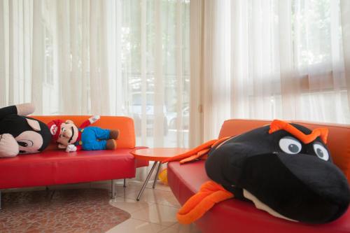 a room with two red chairs with stuffed animals on them at Villa Silvie Rose in Cesenatico
