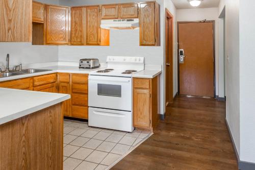 a kitchen with a white stove and wooden cabinets at Super 8 by Wyndham Gardiner/Yellowstone Park Area in Gardiner