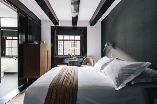a bedroom with a large bed with a black wall at The Dylan Amsterdam - The Leading Hotels of the World in Amsterdam