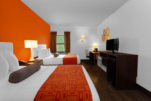 ein Hotelzimmer mit 2 Betten und einem Flachbild-TV in der Unterkunft Howard Johnson by Wyndham Waukegan Great Lakes in Waukegan