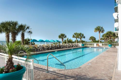 a swimming pool with chairs and palm trees in a resort at Paradise Resort in Myrtle Beach