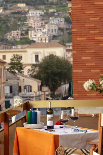 a table with a bottle of wine and two glasses at La Kenzia Casa Vacanze in Maiori