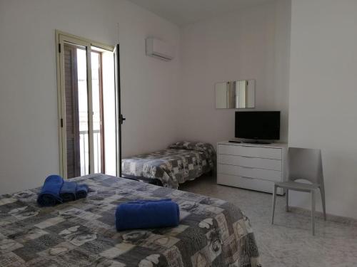 een slaapkamer met een bed, een tv en een stoel bij Indipendence's house in Ispica