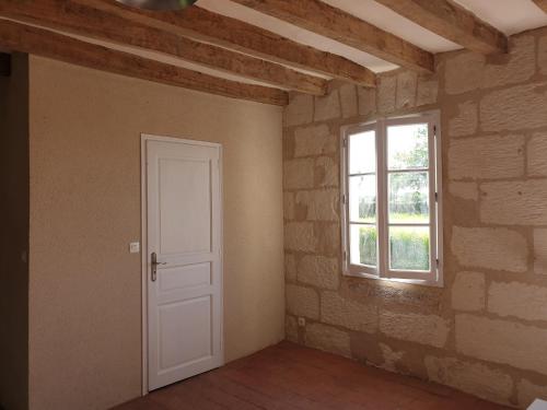 an empty room with a door and a window at Bois logis in Bléré