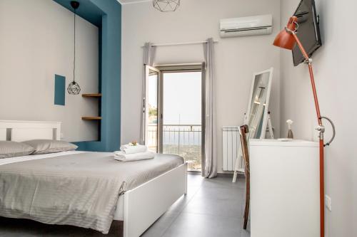 una camera con un letto bianco e una parete blu di Guest House Nonnolorè a Agrigento