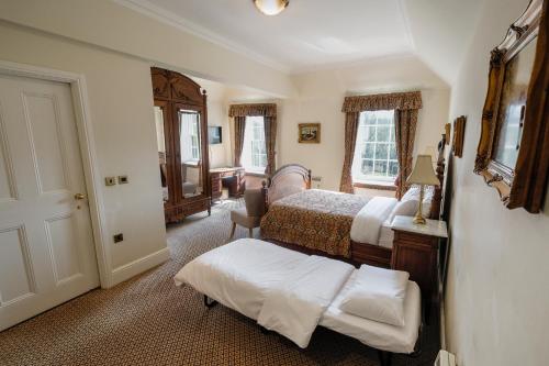 a bedroom with two beds and a table in it at Beamish Hall Country House Hotel, BW Premier Collection in Stanley
