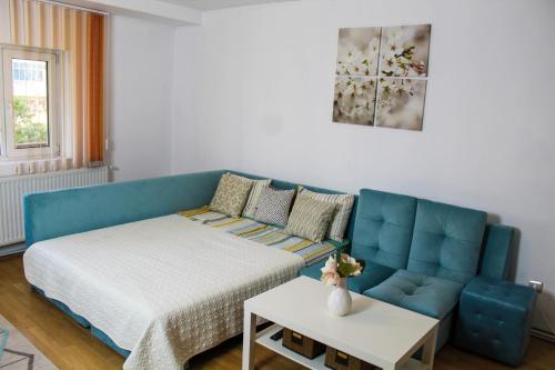 a living room with a blue couch and a table at Collosal Apartment with Garden in Bucharest