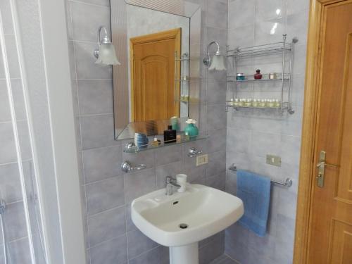 a bathroom with a sink and a mirror at Casavacanze PugliaMia in Grottaglie