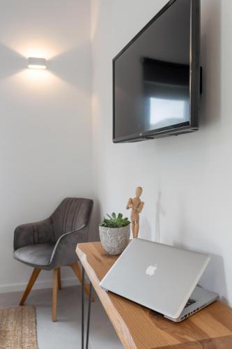 a laptop on a wooden table with a chair at Hvar Top View Apartments in Hvar