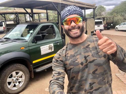 un hombre dando un pulgar al lado de un camión en Kruger Inn Backpackers, en Marloth Park