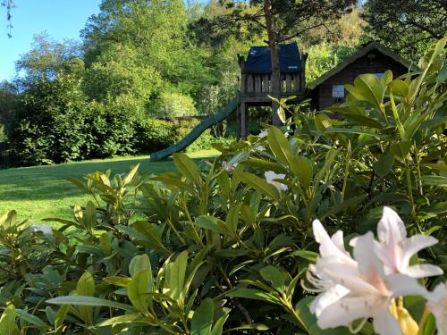 a garden with a bird house in the background at Villa Agni in Barvaux