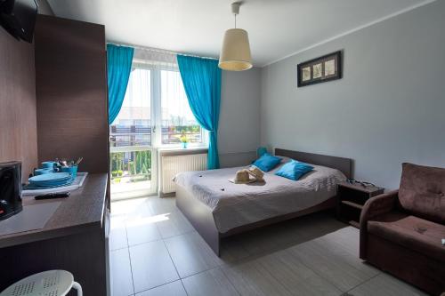 a bedroom with a bed and a chair and a window at Dworek Karwia u Ewy Wiosenna 10 in Karwia