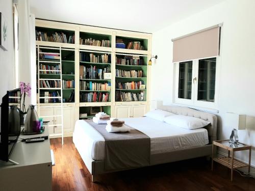 ein Schlafzimmer mit einem Bett und Bücherregalen mit Büchern in der Unterkunft Villa Luce B&B in Olbia