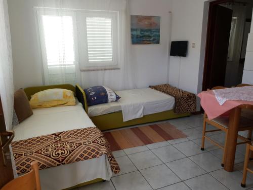 mały pokój z 2 łóżkami i oknem w obiekcie Apartments L.Z. w mieście Starigrad-Paklenica