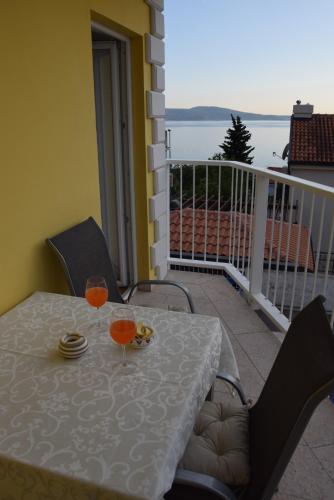 a table with two glasses on top of a balcony at APP LU 5 in Novi Vinodolski