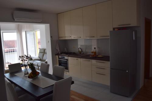 a kitchen with a dining table and a refrigerator at APP LU 5 in Novi Vinodolski