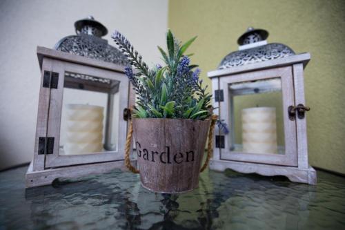 two lanterns and a vase with flowers on a table at Apartman LUNA in Trebinje