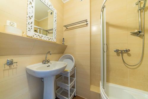a bathroom with a sink and a shower and a toilet at Apartamenty i pokoje Sosnowa 4 Dębki in Dębki