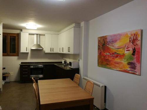 una cocina con una mesa de madera y una pintura en la pared en Apartamento en Primera Linea, en Porto do Son