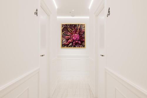 a hallway with white walls and a painting on the wall at Flos Luxury Rooms in Split