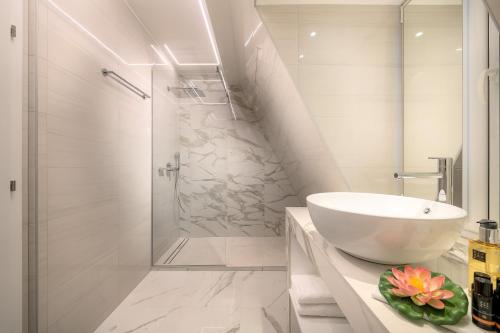 a white bathroom with a sink and a shower at Flos Luxury Rooms in Split