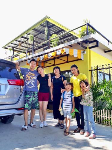 a family poses for a picture in front of a house at Mango House in Sukhothai