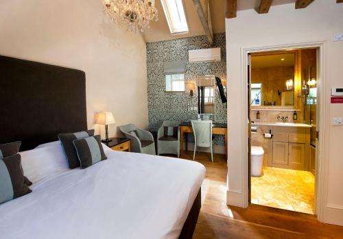 a bedroom with a bed and a kitchen and a bathroom at The Fox by Greene King Inns in Bury Saint Edmunds